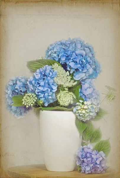 蓝色的绣花花花和安妮女王的花边花束装在一个乳白色的壶里 上面覆盖着柔软的纹理 — 图库照片