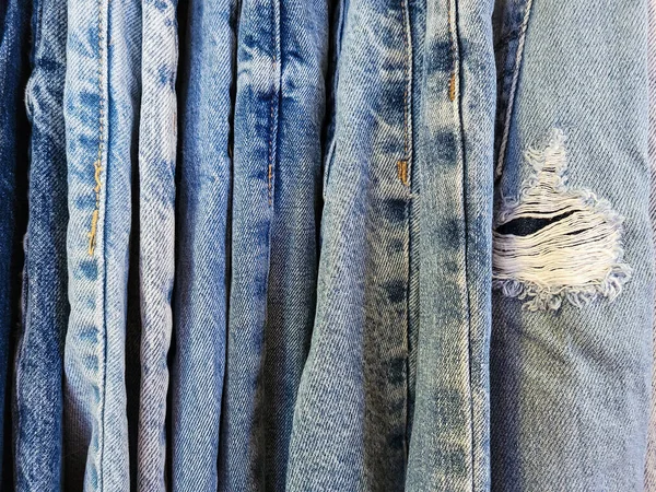 Close-up of distressed blue jeans with a frayed hole