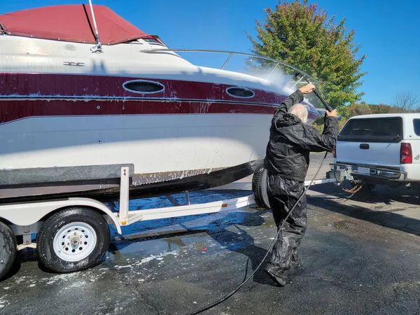 Kaukasischer Mann Wäscht Ein Motorboot Auf Einem Anhänger lizenzfreie Stockfotos