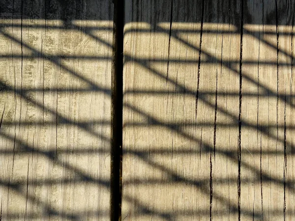 Kahverengi Yıpranmış Ahşabın Üzerindeki Çit Gölgesi Desenine Yakın Plan — Stok fotoğraf