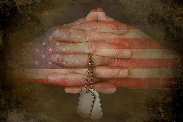 軍事犬のタグを保持する手を祈る上でアメリカ国旗のパターン — ストック写真