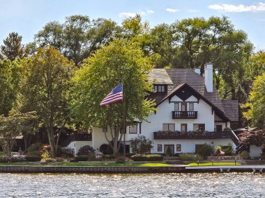 Tudor tarzı ev Amerikan bayrağıyla yaz ağacında