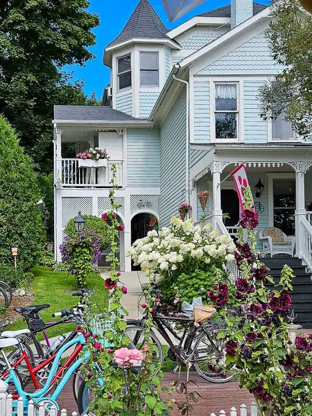 Victorian house with summer flower garden and bicycles