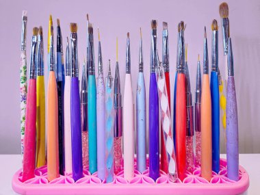 Pembe plastik bir tutacakta renkli manikür tırnak fırçaları