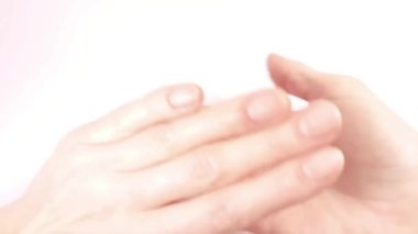 Kadın elinin yavaş hareketi. Hafifçe birbirlerinin avuçlarına dokunuyorlar. Parlak bakımlı bir cilt ve düzgün manikürlü doğal sağlıklı tırnaklar. Yakın çekim görünümü