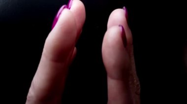 Tırnak cilası reklam yaratıcı video. Tırnak tasarımı ve mor jöle ojeli şık manikür ve parlak kauçuk palto. Parmakları kameraya doğru kaydırıyorum. Kadın elinin parmakları yavaş hareket ediyor. 
