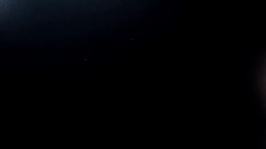 Tırnak sanatı ve manikür yaratıcı konsepti. Tırnak cilası ve palto reklam videosu. Pürüzsüz, yavaş çekim ve siyah arka planda mor tırnaklı bir kadının parmaklarına dokunmak.