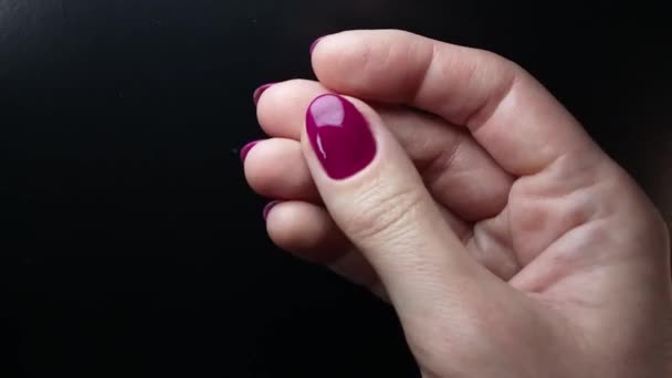 雌性的右手在黑色的背景上展示了她修剪过的紫色指甲 凝胶指甲油的明亮的饱和紫色 特写镜头 — 图库视频影像
