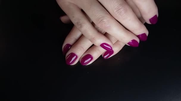 指甲艺术 在黑色的背景上涂上理想的紫胶修指甲 特写女人的手慢慢地碰到另一只手 漂亮的女性指甲 温泉和指甲的概念 — 图库视频影像