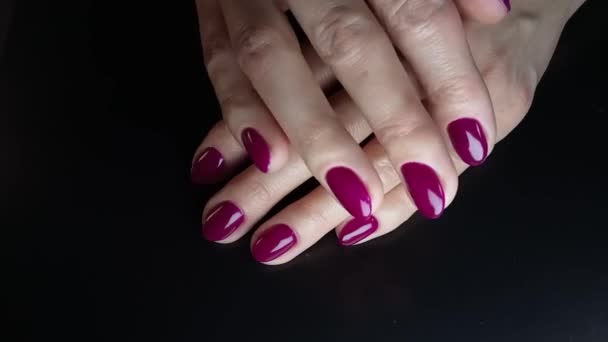指甲艺术和指甲修整 女人把手放在另一只手的手势上 富有紫色的指甲油和柔软的白色皮肤在黑色的背景 女性修指甲的手指特写 — 图库视频影像