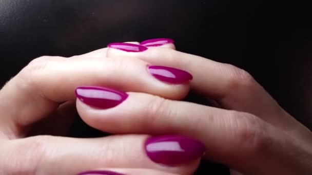 手部互相交错 手部轻柔接触和揉搓 有漂亮优雅修指甲的女性手 白皮肤 亮紫色指甲油在黑色的背景上 手部护肤概念 — 图库视频影像