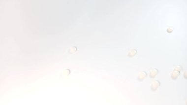 Küçük beyaz yuvarlak haplar kavanozdan masaya döküldü. İlaç, vitamin, sağlık, tedavi kavramı