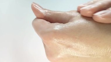 Kadın nemlendirici cilt losyonu sürerek cildine kadın güzellik ürünleri sürmüş. Yavaş masaj hareketleri. Yakın çekim.