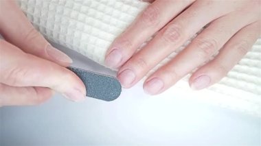 Jel cilası manikür, adım adım video eğitimi. 3. Adım Tırnakları cilalamak ve 4. Adım Toz Fırçalamak. Kadın minder desenli tırnak yüzeyi yapıyor ve tırnak fırçasıyla tırnak yüzeyinden toz parçacıkları çıkarıyor.