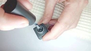 Jel cilası manikür, adım adım video eğitimi. Çivi tabanlı manto. Bir kadın bir şişe jöle cilası açar ve kumaşın akışkanlığını ve tutarlılığını gösterir.