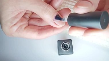 Jel cilası manikür, adım adım video rehberi. 7. adım Nails astarı. Bir kadın baş parmağını jel kaplamayla kaplıyor ve çivinin kenarını kapatıyor. Evde manikür konsepti