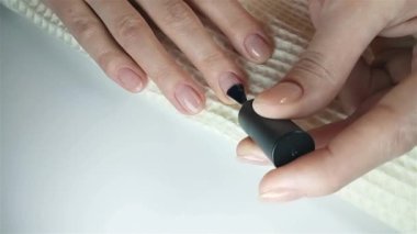 Jel cilası manikür, adım adım video eğitimi. 7. adım Nails astarı. Kadın ellerine yakın çekim. Tırnakları şeffaf taban jel ojesiyle kapla. Evde manikür konsepti