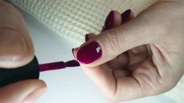 Jel cilası manikür, adım adım video eğitimi. 8. adım oje sürme. Bir kadın oje sürdükten sonra tırnağın kenarını jöleyle kaplıyor. Özbakım ve güzellik kavramı 
