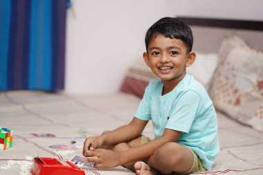 Yatağında Scrabble alfabesi olan neşeli çocuk. Çocuk projeleri için ideal. Öğrenmek için ilgi çekici kavram. Web siteleri, reklamlar ve eğitim için mükemmel.