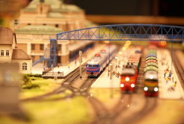 Tren istasyonunda vagonları olan bir lokomotif. Demiryolu, arabalar, konut ve sanayi binaları olan bir peyzaj. Mimari ve manzaralı anıtlar. Minyatür inşa etme hobileri