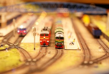 Tren istasyonunda vagonları olan bir lokomotif. Demiryolu, arabalar, konut ve sanayi binaları olan bir peyzaj. Mimari ve manzaralı anıtlar. Minyatür inşa etme hobileri