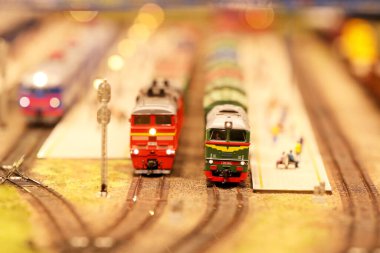 Tren istasyonunda vagonları olan bir lokomotif. Demiryolu, arabalar, konut ve sanayi binaları olan bir peyzaj. Mimari ve manzaralı anıtlar. Minyatür inşa etme hobileri