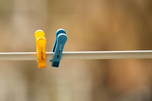 ロープの上に青と黄色の服ピンが2つ ウクライナとスウェーデンの国旗の象徴 洗濯や掃除 日常生活の組織のための家庭用品 毎日のプラスチック製品 — ストック写真