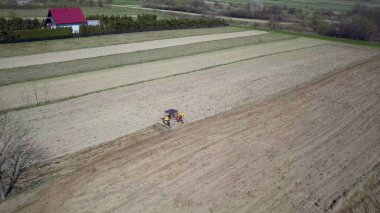 Bir tohumile traktör bir çiftçi köy bölgesinde özel bir alanda sürülmüş arazi tahıl ekiyor. Bahar saha çalışmalarının mekanizasyonu. Çiftçinin günlük hayatı. Arazinin işlenmesi. Tarımsal.