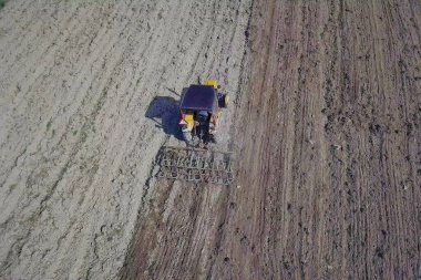 Bir tohumile traktör bir çiftçi köy bölgesinde özel bir alanda sürülmüş arazi tahıl ekiyor. Bahar saha çalışmalarının mekanizasyonu. Çiftçinin günlük hayatı. Arazinin işlenmesi. Tarımsal.