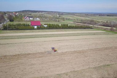 Bir tohumile traktör bir çiftçi köy bölgesinde özel bir alanda sürülmüş arazi tahıl ekiyor. Bahar saha çalışmalarının mekanizasyonu. Çiftçinin günlük hayatı. Arazinin işlenmesi. Tarımsal.