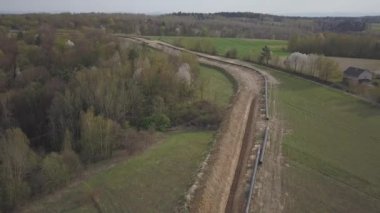 Yeşil tepelerin arasına gaz boru hattı döşenmesi. Kazılan sipere dalmak için hazırlanmış büyük yüksek basınçlı çelik borular. Stratejik endüstride arazi işleri. Enerji ve doğal kaynaklar