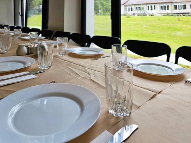 Büyük bir yemek odasında uzun bir masa servis ettim. Masada çatal bıçak takımı var. Davetsiz düğün masası. Büyük bir grup insan için önemli etkinlikler vesilesiyle tören şölenleri salonu.