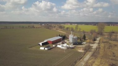 Yeşil tepelik alanlar arasında yer alan büyük bir çiftlik yüksekliğini görünümden. Bir uçak veya bir quadro videodan. Paslanmaz çelik silo ile Agro-endüstriyel kompleks. Organik gıda üretimi. Süt sanayî için