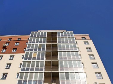 Lviv, Ukrayna - 342020: Balkonları ve büyük cam pencereleri olan çok katlı modern bir evin cephesi. Modern mimari tasarımı. Alttan üstten bak. Modern şehir mimarisi.