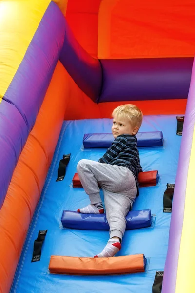 Cute Boy Climbs Colorful Ladder High Inflatable Trampoline Looks Distance — Stock Photo, Image