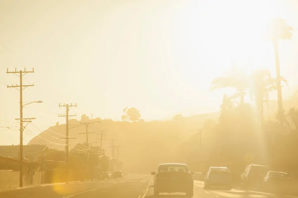 日没時に道路を走行する車 — ストック写真