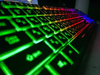 Karanlıkta parlayan çok renkli bir oyun klavyesinin yakın açılışı.