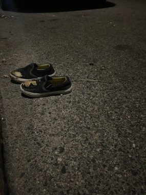 Parçalanmış çocuğun ayakkabıları beton yolda terk edilmiş.