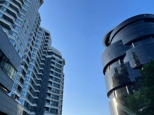 阳光普照的蓝天下 现代公寓楼和黑色玻璃商务中心摩天大楼层出不穷 — 图库照片