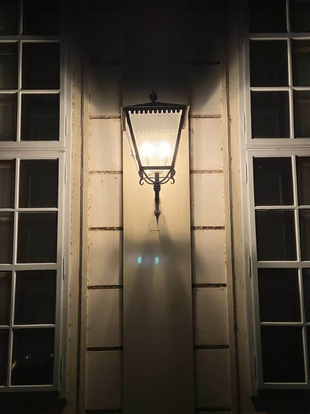 Pionowe Ujęcie Lampy Ulicznej Rocznika Świecącej Ciemności Wiszącej Ścianie Domu — Zdjęcie stockowe