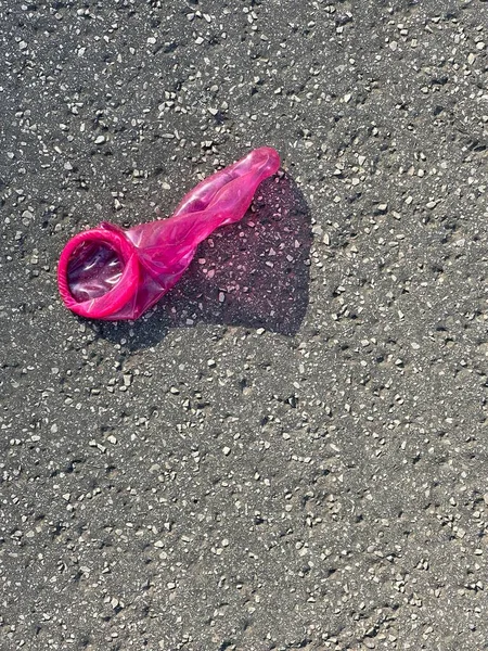 人行道上使用过粉色避孕套 — 图库照片
