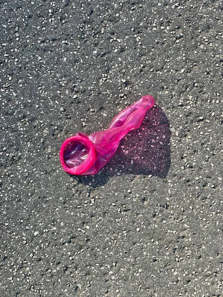 用粉红胶乳避孕套扔在城里的地上 — 图库照片