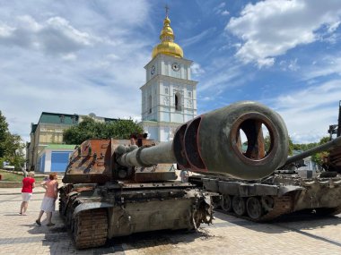 Ukrayna 'da savaş. Tank namlusu kapalı, kilise arka planda. 17 Haziran 2022 'de Ukrayna' nın başkenti Kyiv 'de tahrip edilen askeri araçlara bakılıyor. 