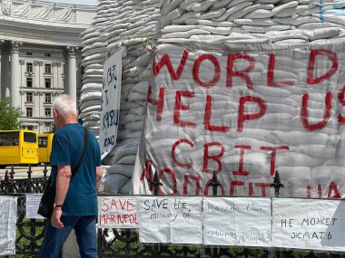 Ukrayna 'daki savaş sırasında yardım isteyin. Beyaz bayrağa yazılı Dünya Yardım Örgütü, Ukrayna 'nın başkenti Kyiv' de yürüyor - 17 Haziran 2022