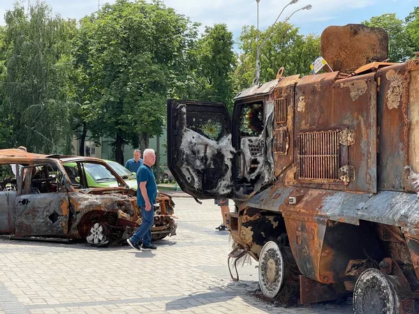 乌克兰战争 2022年6月17日 在乌克兰基辅被毁烧毁车辆之间行走的老年人 — 图库照片