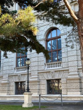 Çam ağaçlarının yakınındaki güzel bir binada çarpıcı eski moda kemerli pencereler.