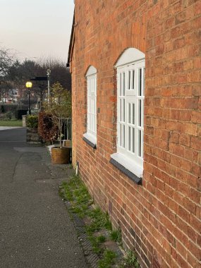 White windows in the wall of a brick house in old town