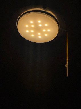 Low angle shot of minimalist lamp glowing with warm yellow light