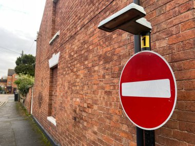 Kırmızı, eski kasabadaki tuğla duvarın yanında trafik levhası için giriş yasak.