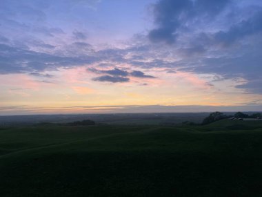 Tepeler ve vadiler üzerinde dramatik günbatımı manzarası